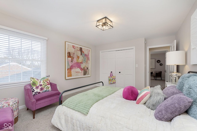 bedroom with multiple windows, carpet floors, and a closet