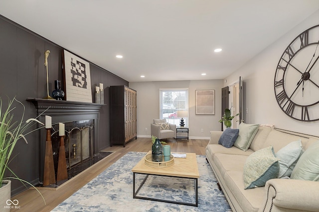 living room with a large fireplace and light wood-type flooring