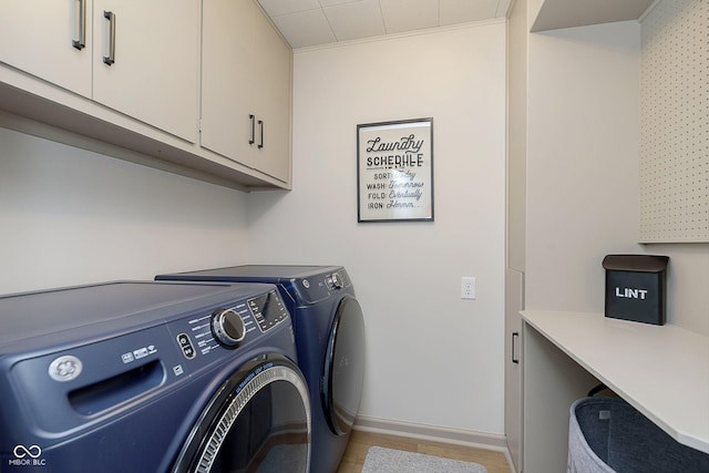 laundry room featuring cabinets, light wood-type flooring, and independent washer and dryer