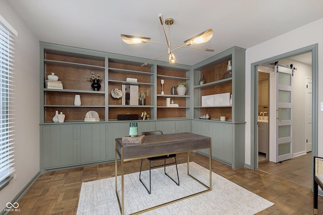 office with built in features, a barn door, and dark parquet floors