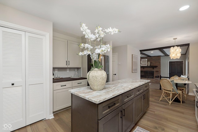 kitchen with tasteful backsplash, beam ceiling, hardwood / wood-style floors, and pendant lighting