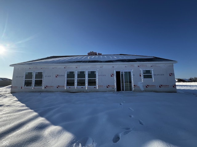 view of snow covered back of property