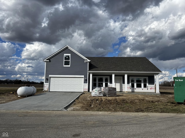 traditional-style house with roof with shingles, a porch, concrete driveway, a garage, and cooling unit