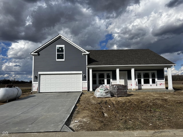 traditional-style home with driveway, an attached garage, a porch, and a shingled roof