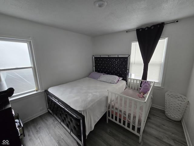 bedroom featuring a textured ceiling and dark hardwood / wood-style flooring