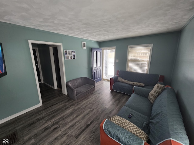 living room featuring a textured ceiling and dark hardwood / wood-style flooring