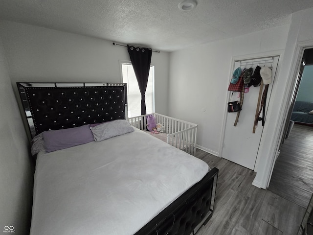 bedroom featuring a textured ceiling and hardwood / wood-style flooring