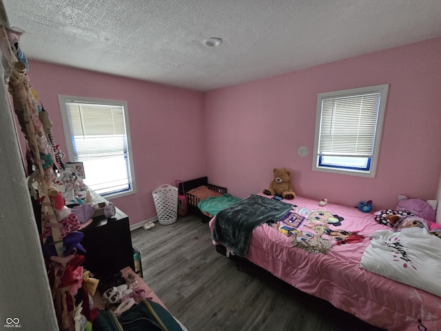 bedroom with a textured ceiling and hardwood / wood-style floors