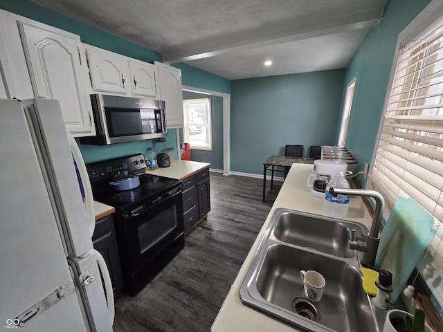 kitchen with white fridge, white cabinetry, beamed ceiling, electric range, and sink