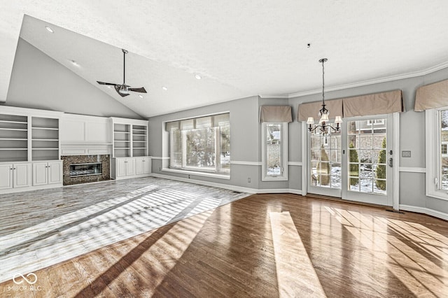 unfurnished living room featuring a healthy amount of sunlight, hardwood / wood-style floors, and a high end fireplace