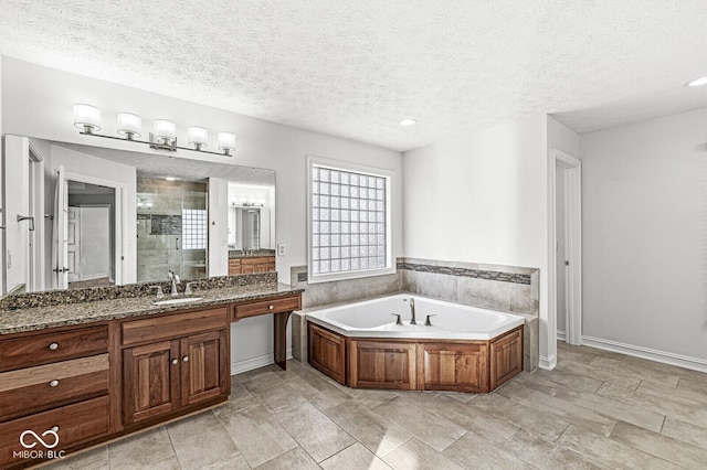 bathroom with vanity, plus walk in shower, and a textured ceiling