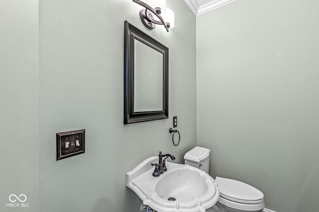 bathroom with crown molding, sink, and toilet