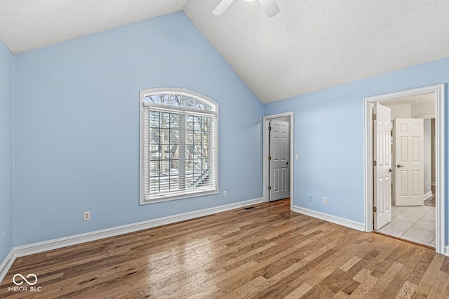 unfurnished bedroom with ensuite bath, high vaulted ceiling, ceiling fan, and light wood-type flooring