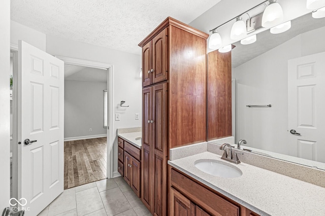 bathroom featuring vanity, tile patterned flooring, and a textured ceiling