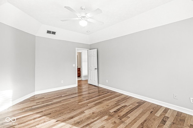 spare room with vaulted ceiling, ceiling fan, and light wood-type flooring