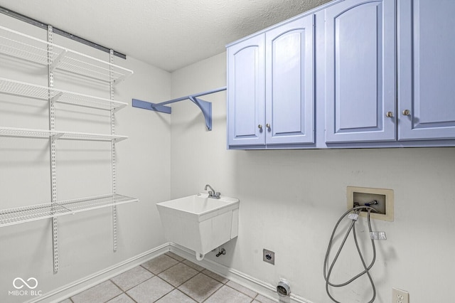 clothes washing area with sink, cabinets, light tile patterned floors, hookup for a washing machine, and hookup for an electric dryer