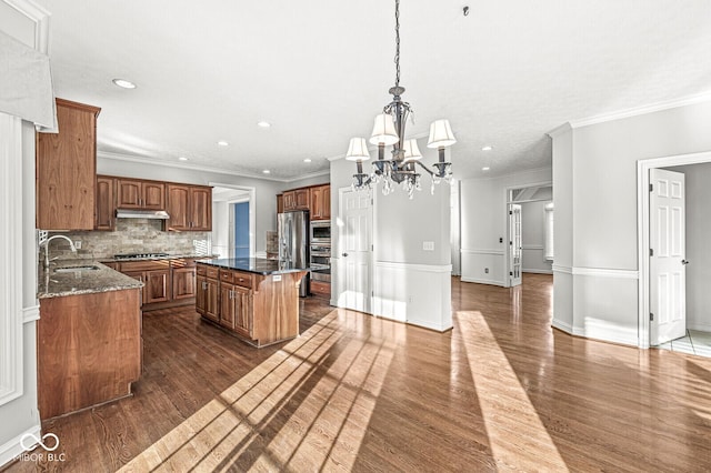 kitchen with ornamental molding, a center island, sink, and decorative backsplash