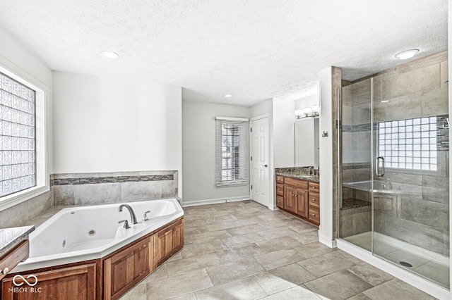 bathroom featuring vanity, a textured ceiling, and separate shower and tub