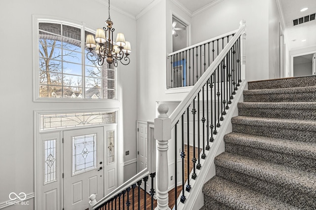 entrance foyer featuring a notable chandelier, a wealth of natural light, and ornamental molding