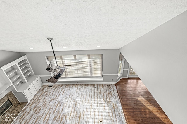 unfurnished living room with vaulted ceiling, dark hardwood / wood-style floors, and a textured ceiling