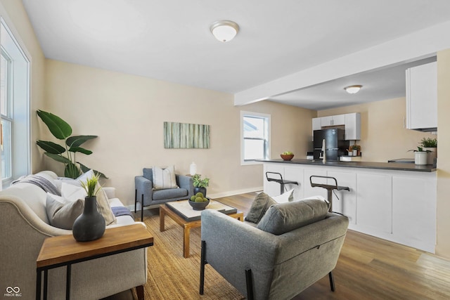 living room with beamed ceiling and light hardwood / wood-style flooring