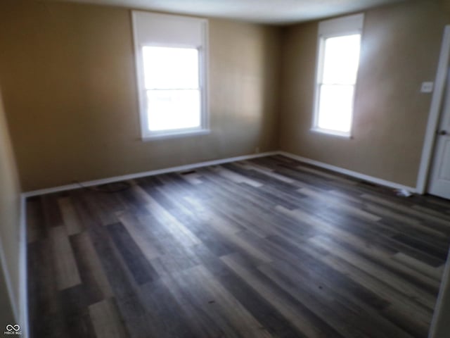 empty room with dark hardwood / wood-style flooring