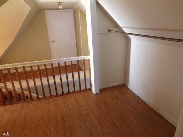 additional living space featuring wood-type flooring and vaulted ceiling