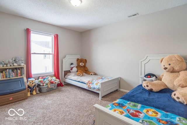 bedroom featuring a textured ceiling and carpet flooring