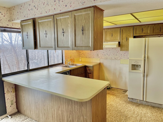 kitchen featuring white refrigerator with ice dispenser, sink, and kitchen peninsula