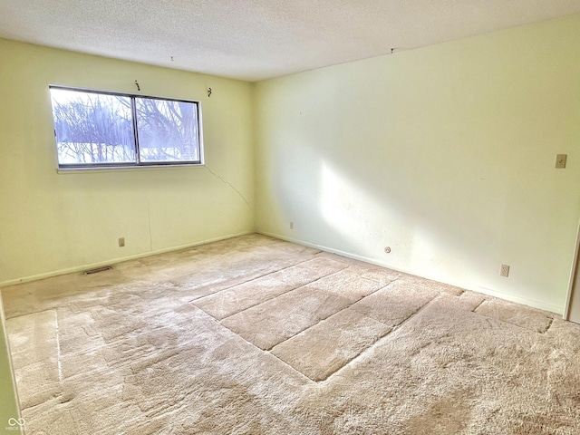 carpeted spare room featuring a textured ceiling