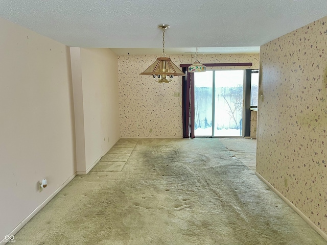 carpeted spare room featuring a textured ceiling