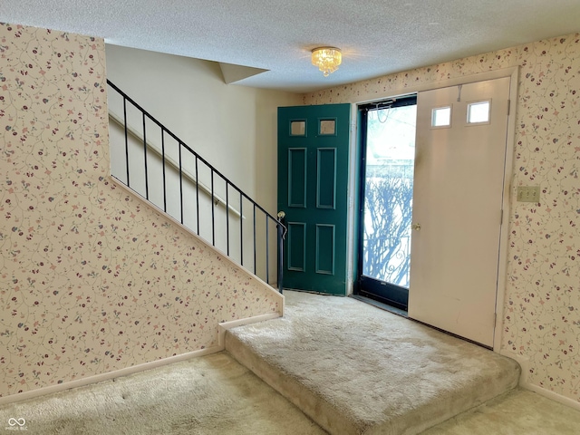 foyer featuring carpet floors and a textured ceiling