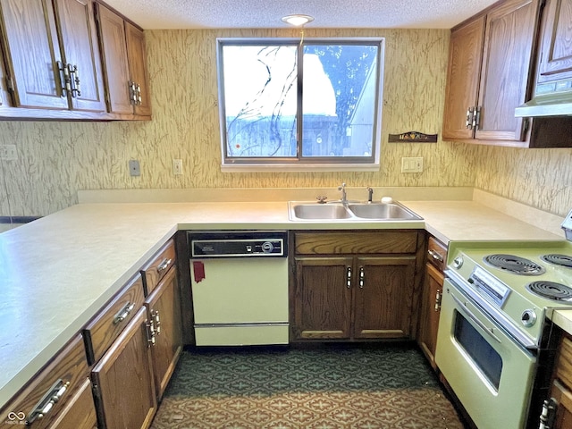 kitchen with white dishwasher, sink, range with electric stovetop, and a textured ceiling