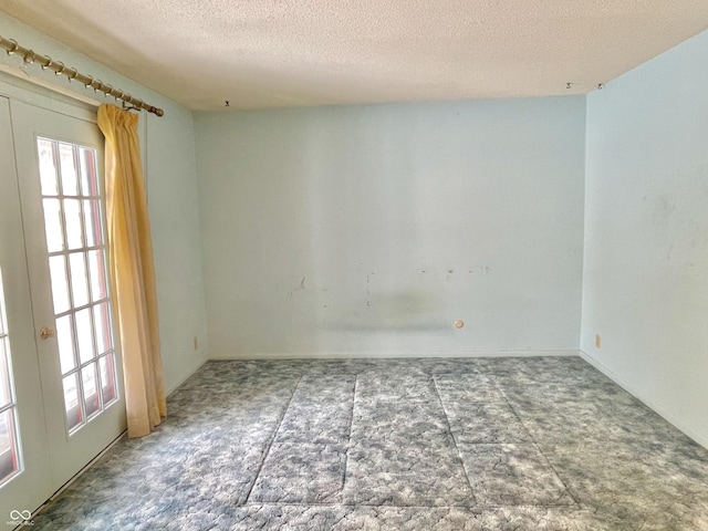 unfurnished room with a textured ceiling and french doors