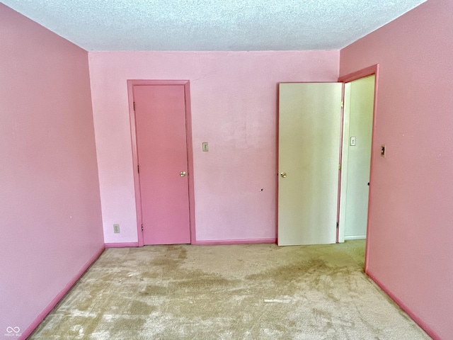 carpeted empty room with a textured ceiling