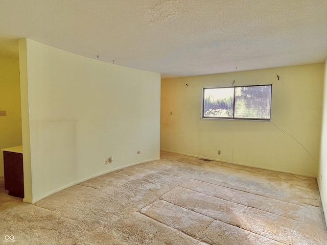 carpeted spare room with a textured ceiling