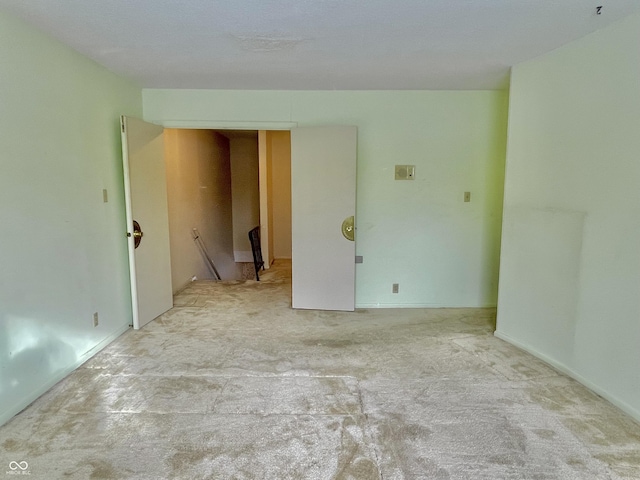 unfurnished room featuring light carpet