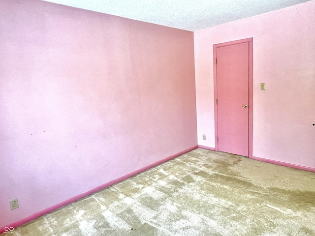 unfurnished room with carpet flooring and a textured ceiling