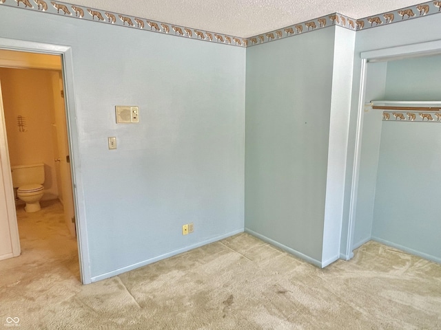 unfurnished bedroom featuring light carpet and a textured ceiling