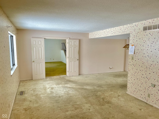 carpeted spare room featuring a textured ceiling