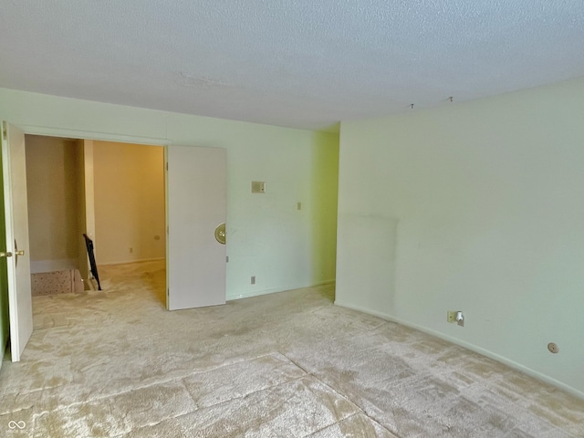 carpeted spare room featuring a textured ceiling