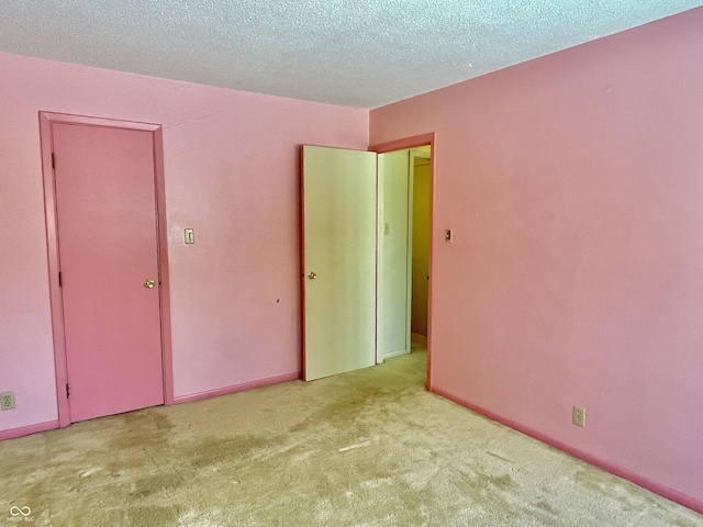 unfurnished bedroom with light carpet and a textured ceiling