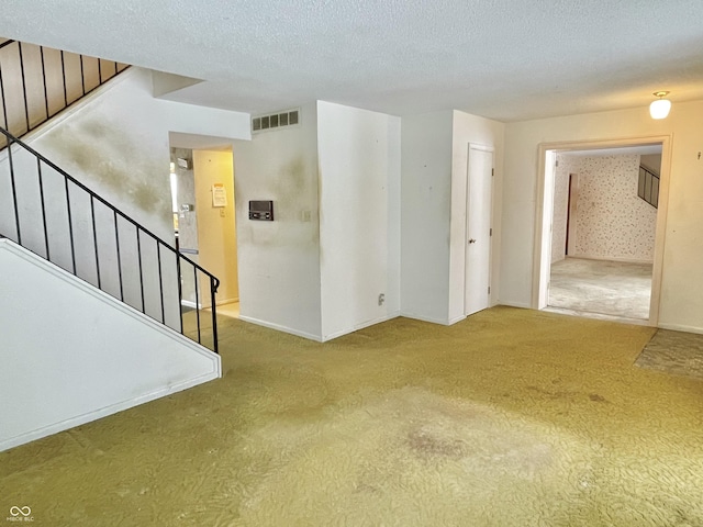 unfurnished room featuring carpet floors and a textured ceiling