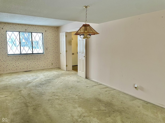 empty room with carpet and a textured ceiling