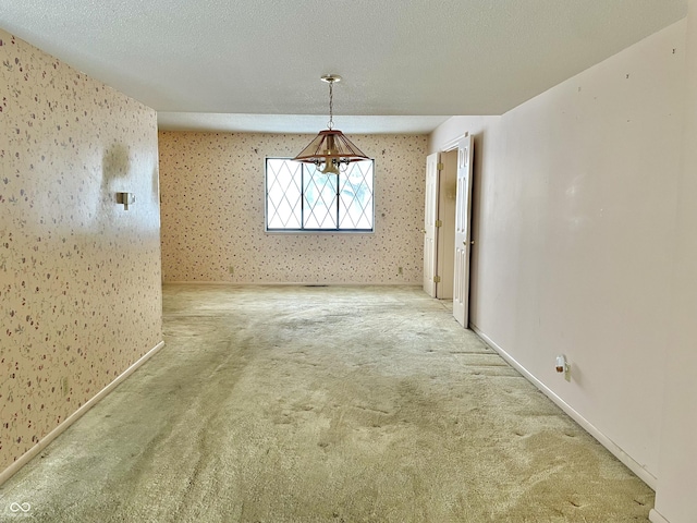 unfurnished dining area with carpet and a textured ceiling