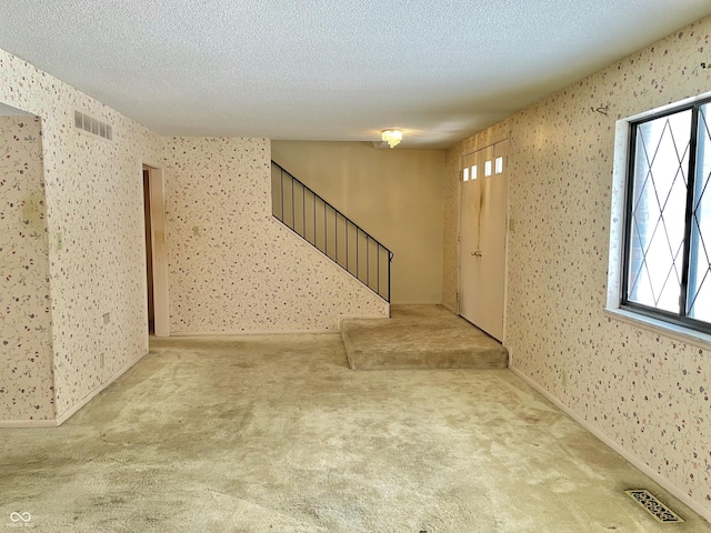 interior space featuring carpet and a textured ceiling