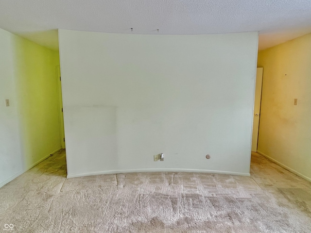 carpeted empty room featuring a textured ceiling