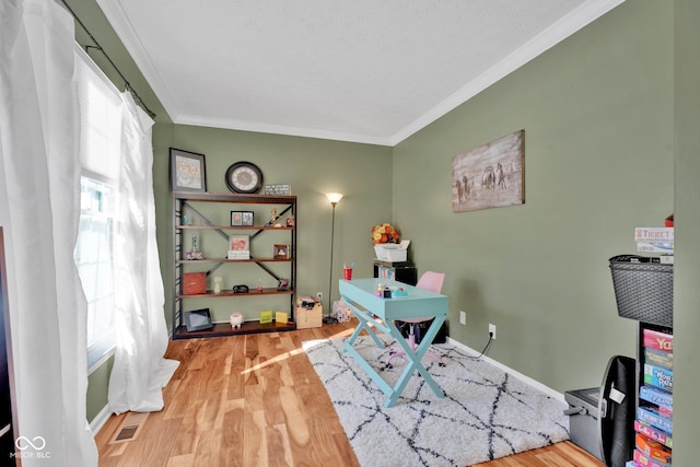 office area featuring a wealth of natural light, wood-type flooring, and ornamental molding