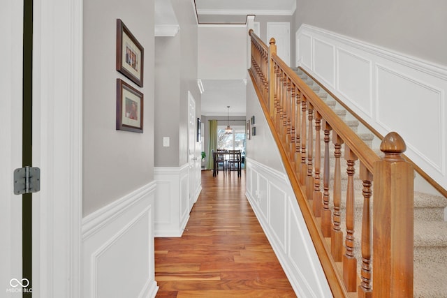 hall with crown molding and light hardwood / wood-style flooring