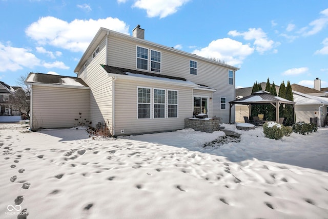 snow covered rear of property featuring a gazebo